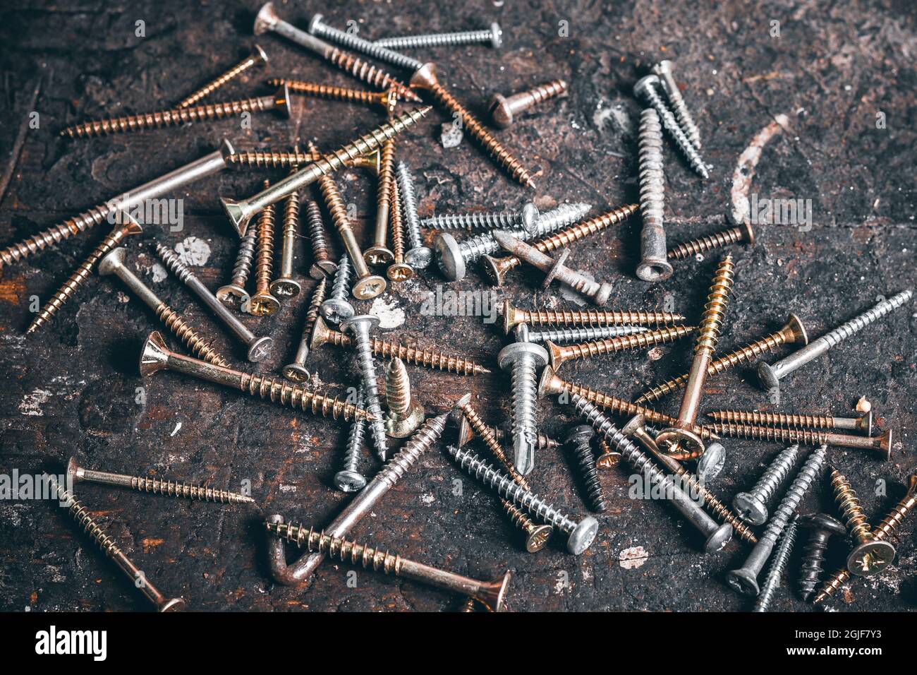 A lot of screws on wood workbench. Different Kind of Screws on a table