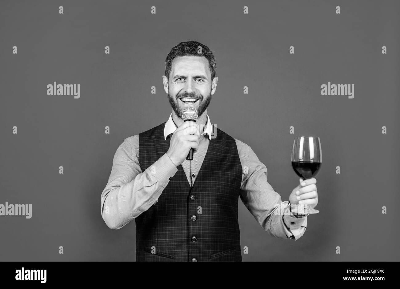 Proposing toast. Toast master speak into microphone lifting glass of