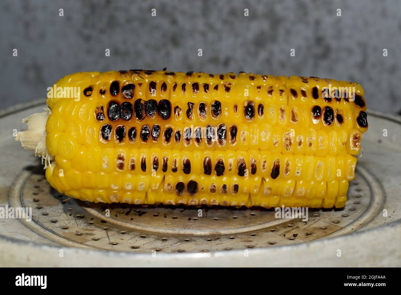 Myanmar or Burmese traditional street food, roasted corn. In medical point of view, it is carcinogenic. Stock Photo