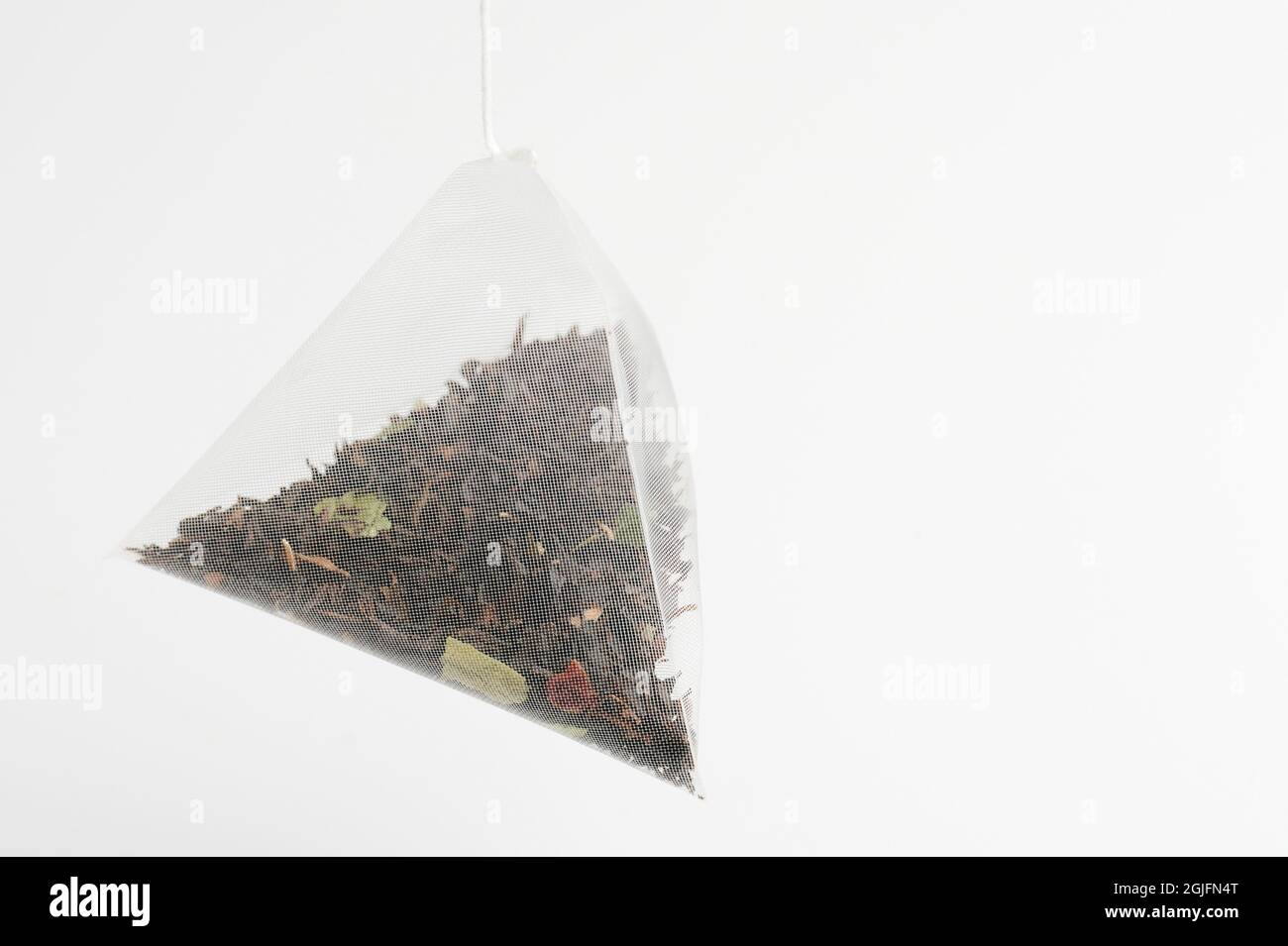 Teabag triangle shape isolated on white studio background  close up view Stock Photo