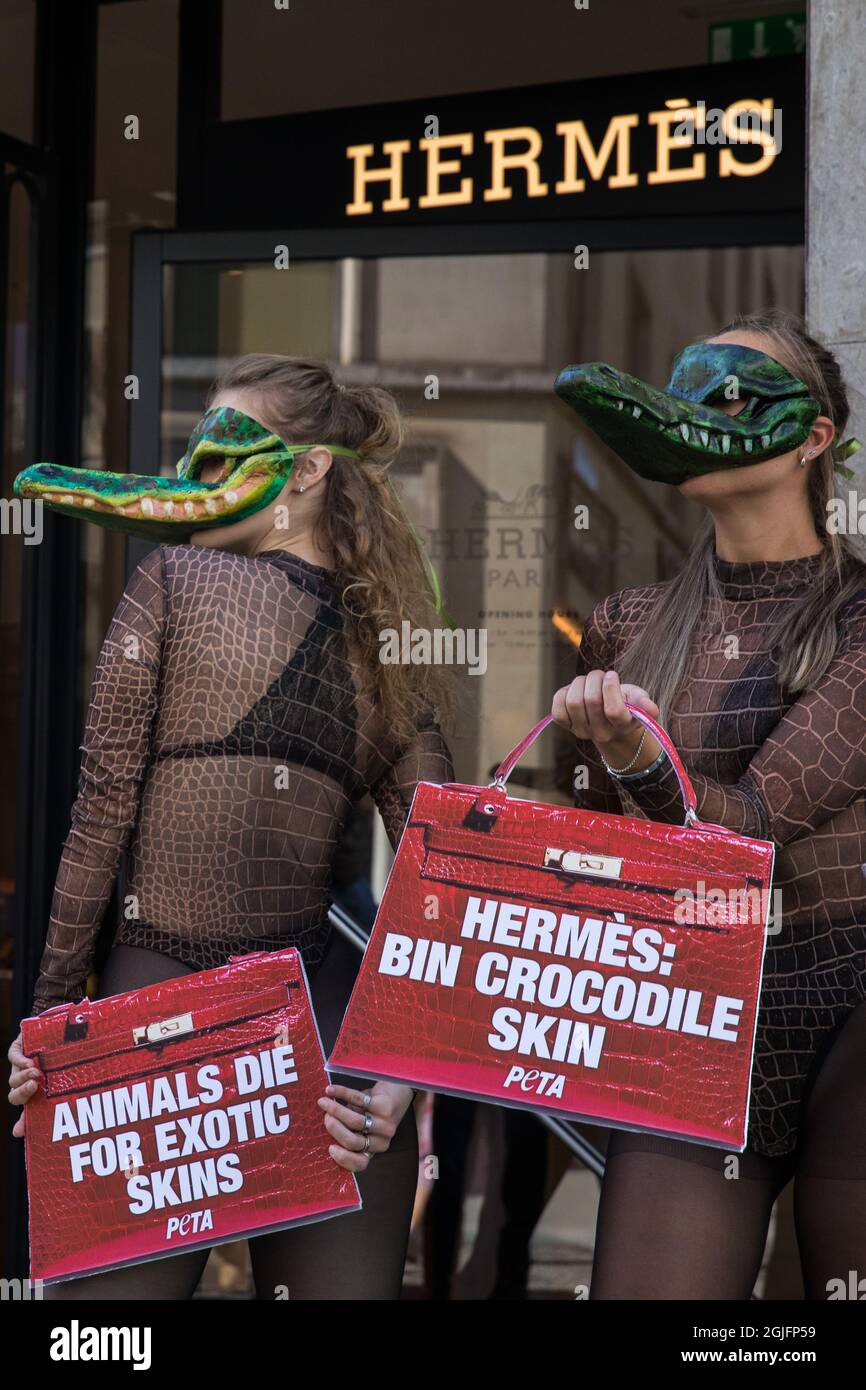London, UK. 8th September, 2021. Two PETA supporters wearing Venetian crocodile masks pose outside the Hermès store in New Bond Street in protest against the luxury fashion house's use of exotic skins. PETA's campaign was launched following the release of video footage by The Kindness Project showing crocodiles being mutilated, electrocuted, stabbed and shot on farms in Australia with ties to Hermès and PETA are calling on the fashion brand to cease using exotic skins for their products. Credit: Mark Kerrison/Alamy Live News Stock Photo