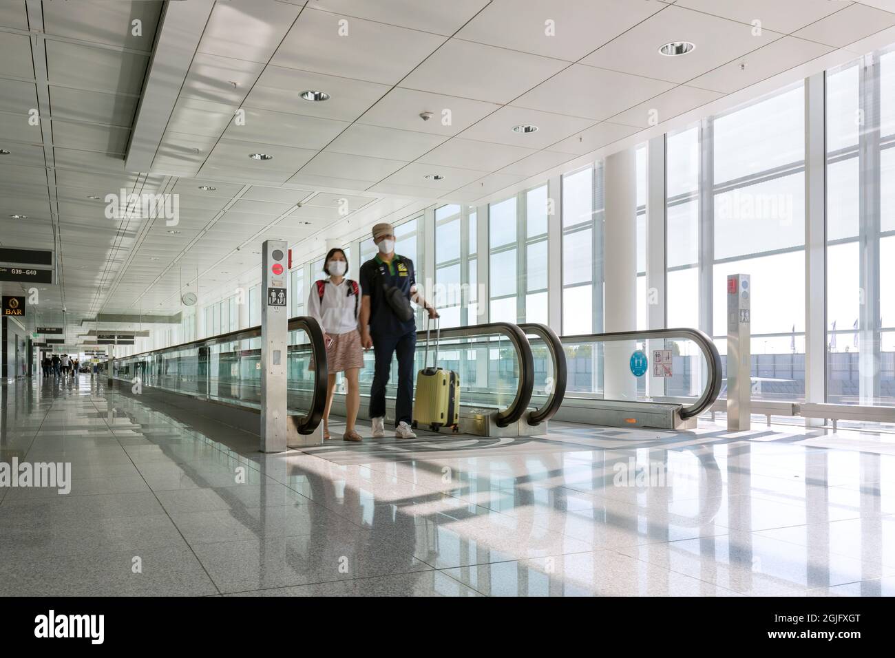 Oslo airport, 05/09/2021: Asian tourist wear face mask, walking on moving  walkway airport, subjects out of focus Stock Photo - Alamy