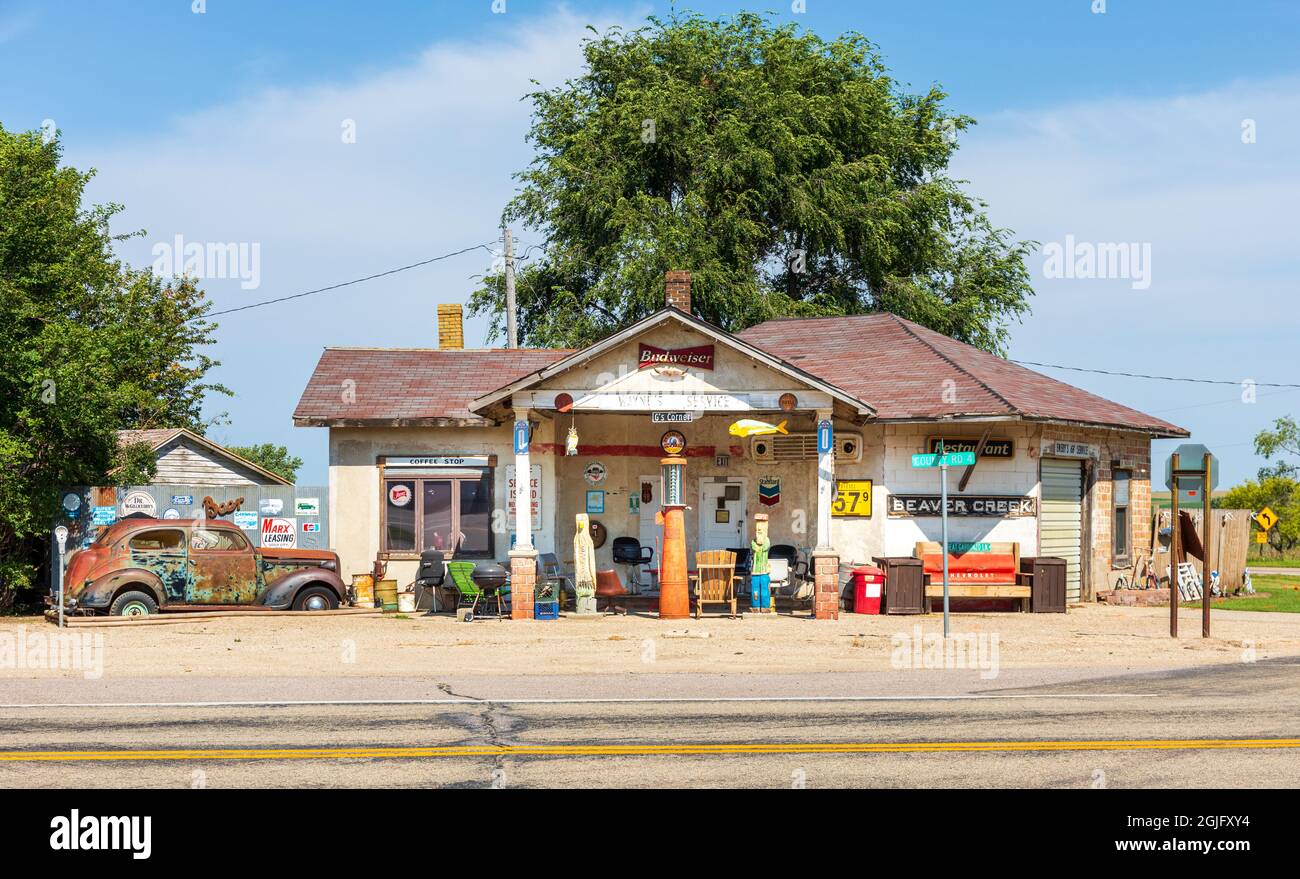 BEAVER CREEK, MN, USA-22 AUGUST 2021: Antique gas station, 1930s car and random items for sale.  Signs include 'coffee stop', 'Wayne's Service'. Stock Photo