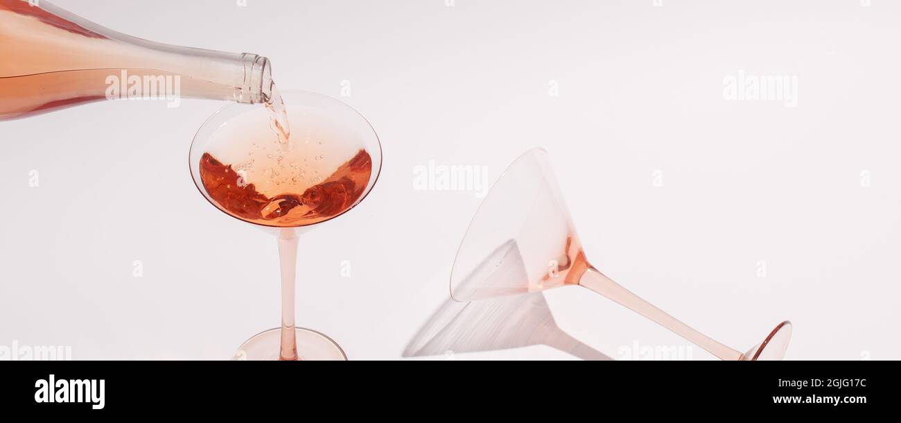 Pouring Rose wine in cocktail rose glass on white background Stock ...