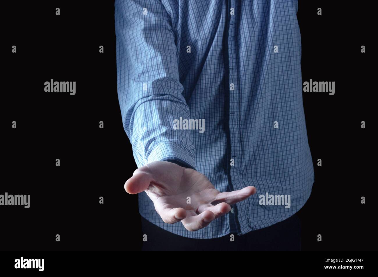 Outstretched hand of a man. A man in a plaid shirt. Hand with an open palm. Stock Photo