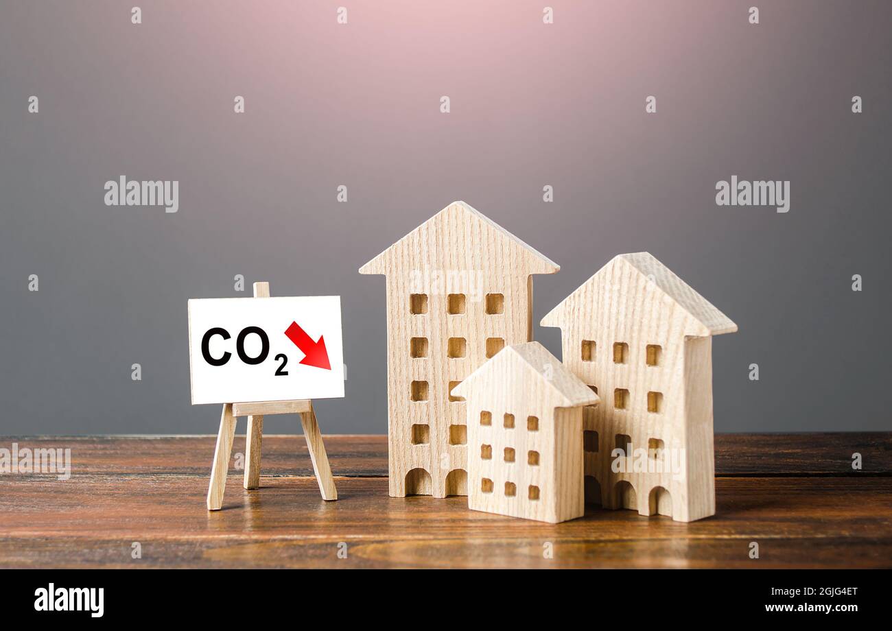 Green house and easel with carbon dioxide reduction. Environmentally friendly. Improving utilities and energy efficiency. Impact on environment. Reduc Stock Photo