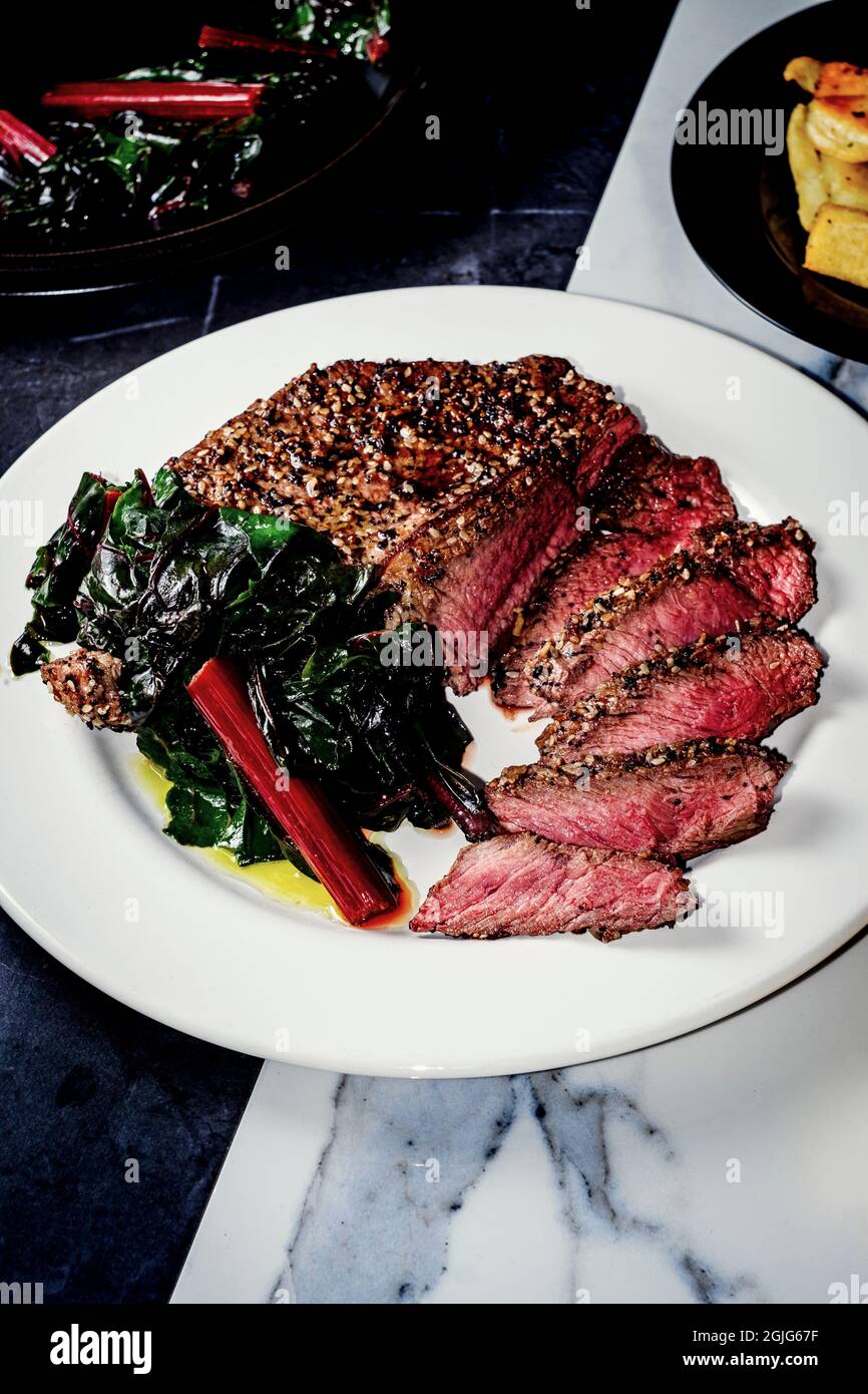 Rare steak with everything bagel seasoning served with red swiss chard Stock Photo Alamy