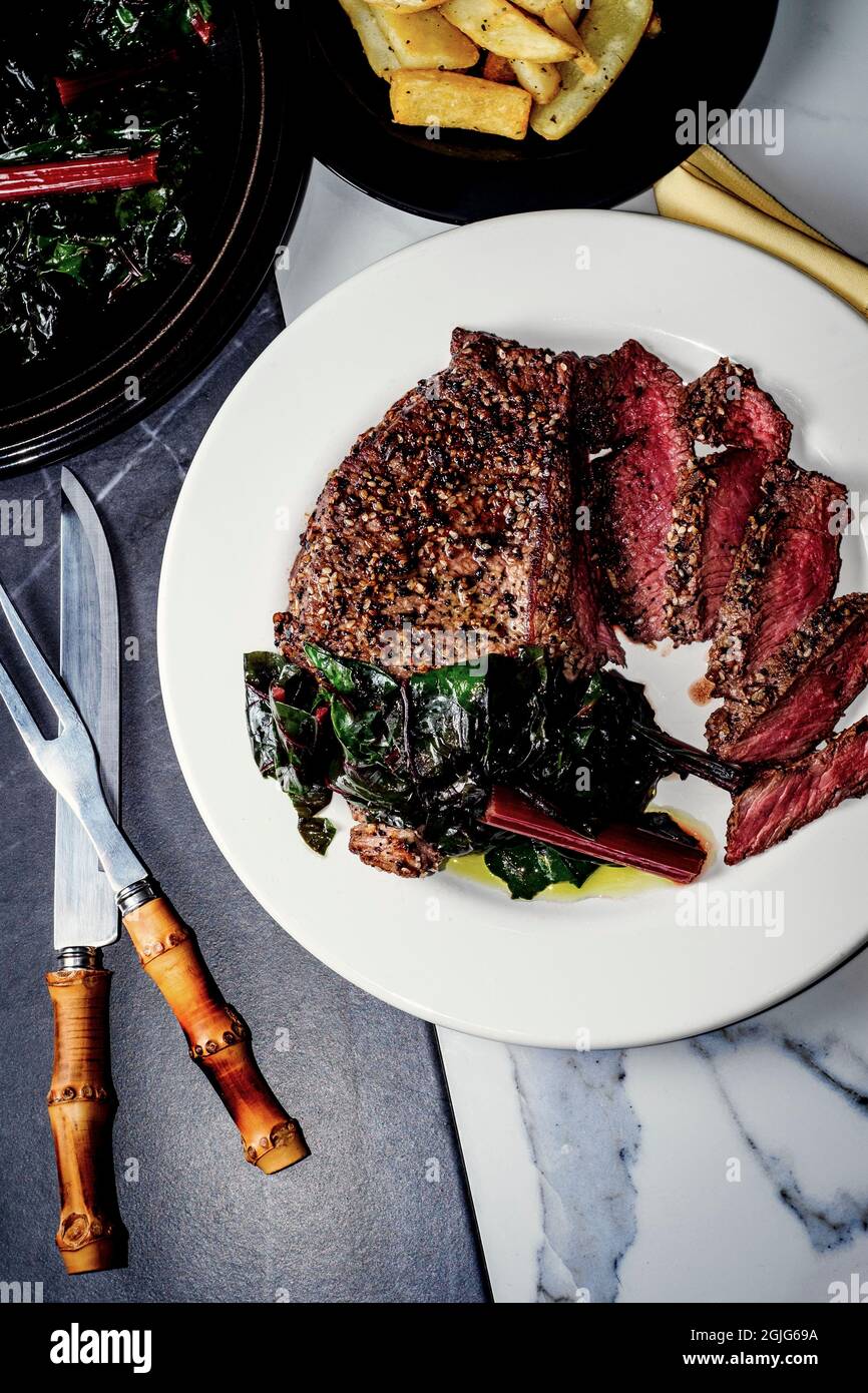 Rare steak with everything bagel seasoning served with red swiss chard Stock Photo Alamy
