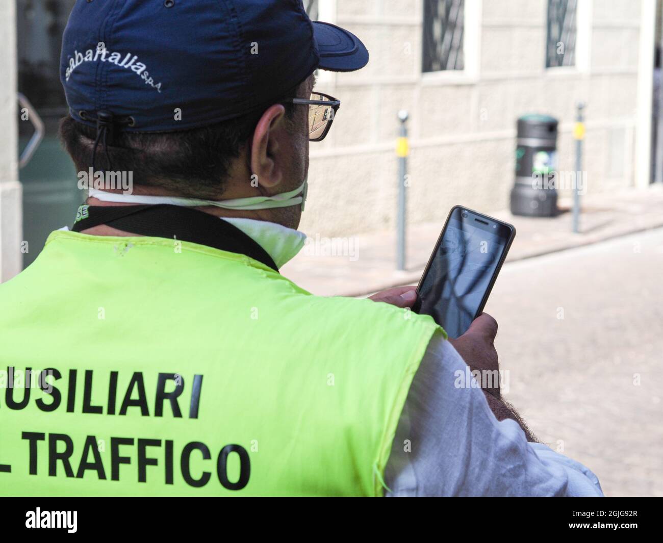 LOMBARDY, ITALY - Aug 19, 2021: A parking warden attendant from a private outsourced company issuing parking violations online printing and leaving th Stock Photo