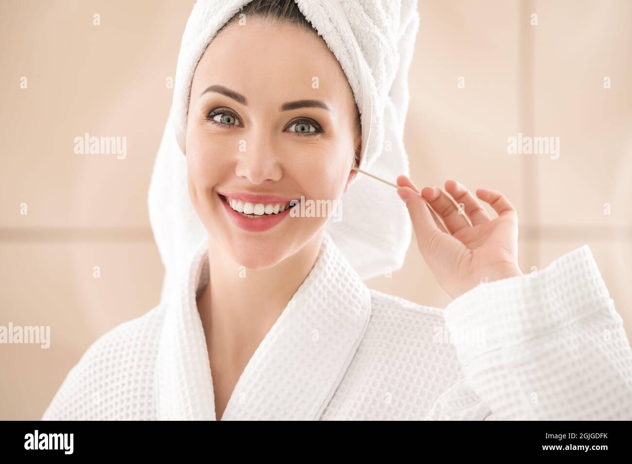 Young woman cleaning ears with cotton bud in bathroom Stock Photo Alamy