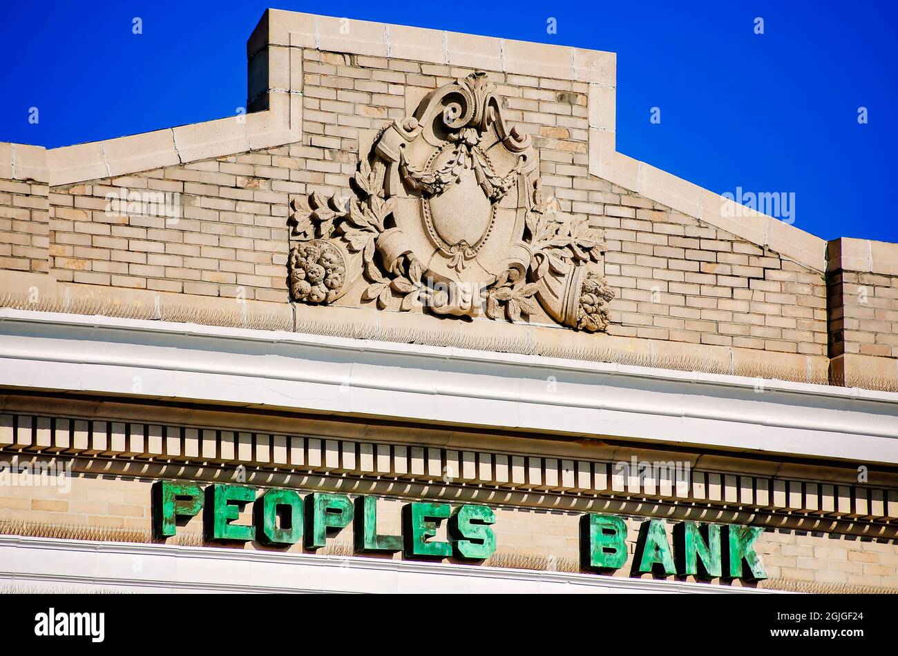 A decorative cartouche is mounted on the parapet of The Peoples Bank