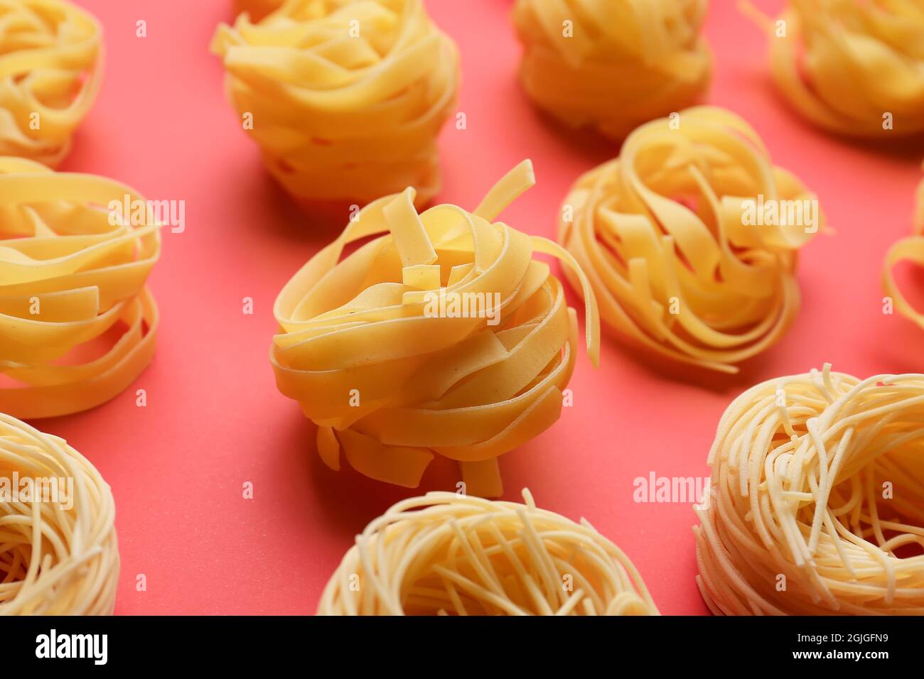 Different types of uncooked pasta on color background Stock Photo - Alamy