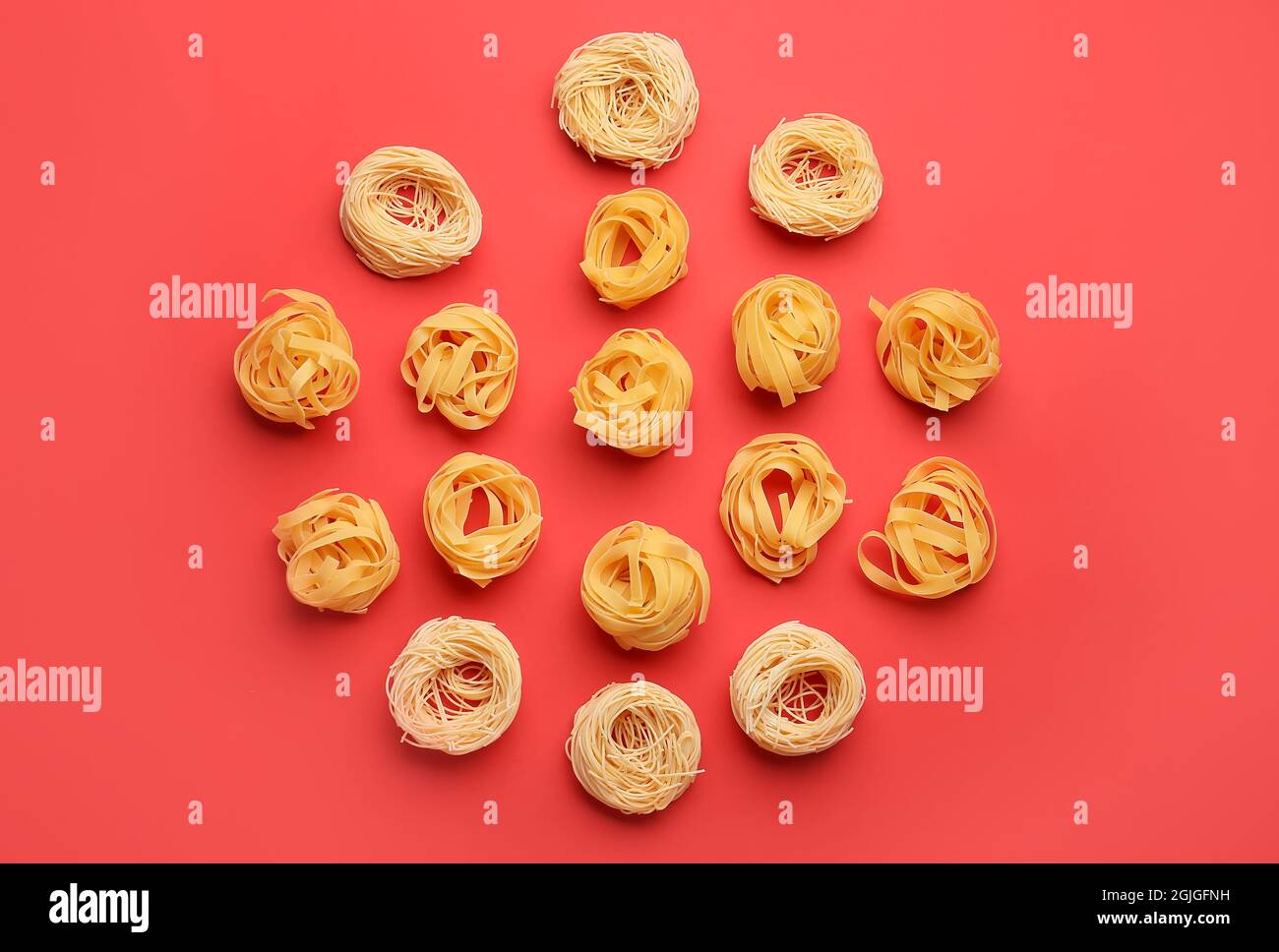 Different types of uncooked pasta on color background Stock Photo - Alamy