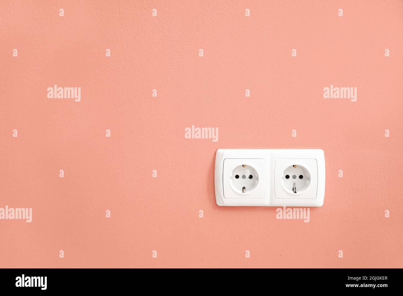 Electric socket on color wall Stock Photo - Alamy