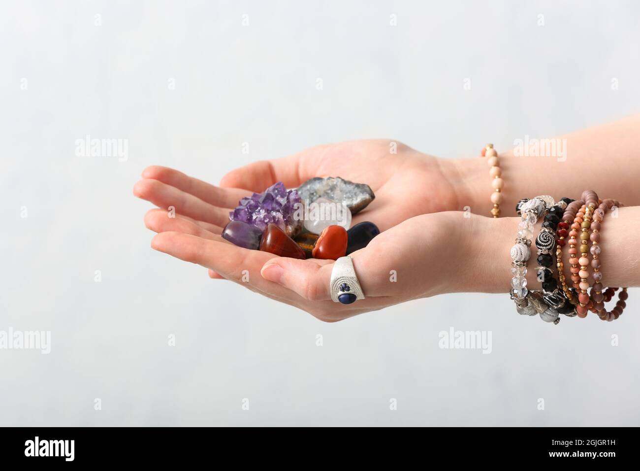 Female hands with beautiful gemstones on light background Stock Photo