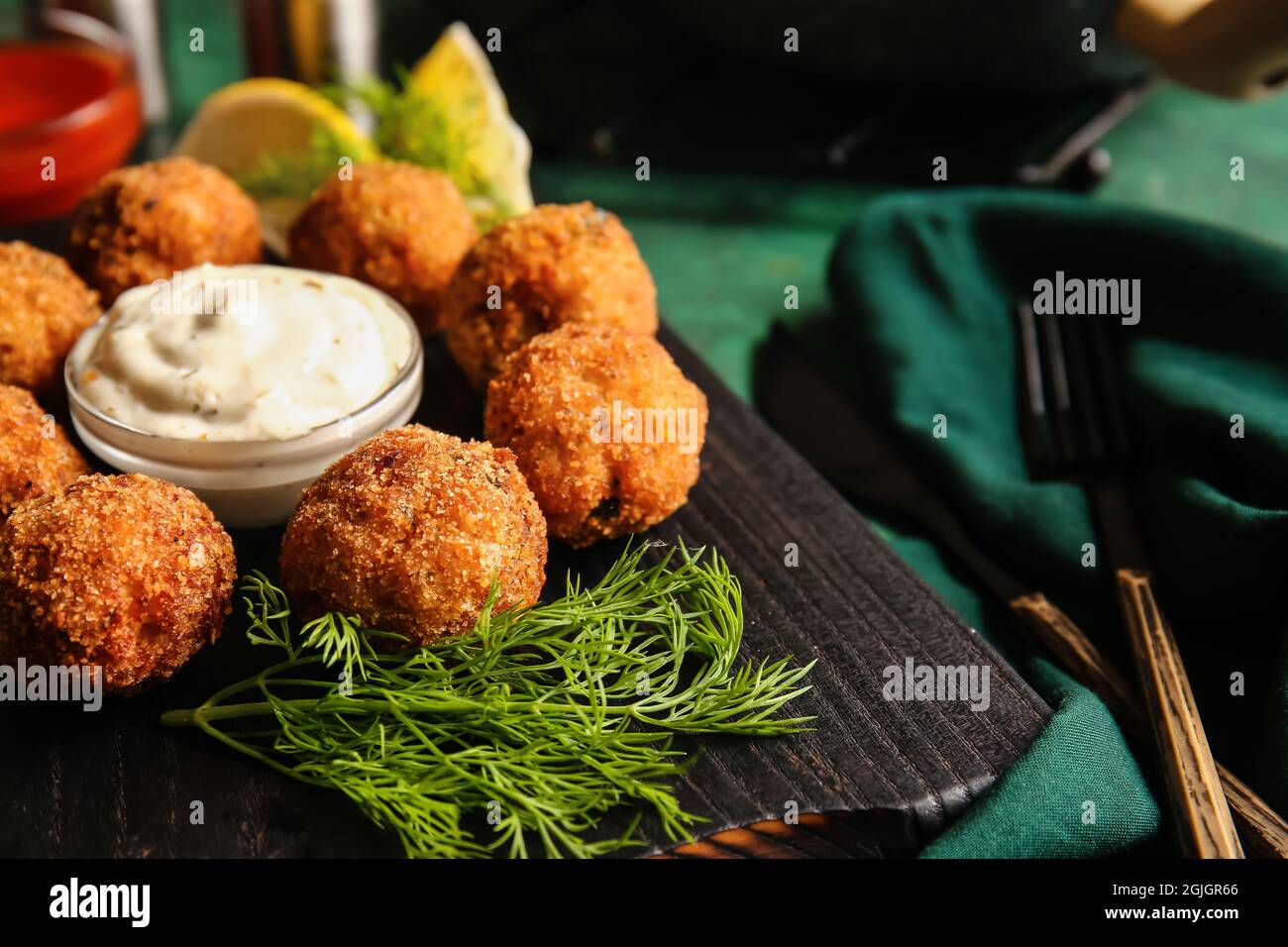 Board with tasty cod cutlets and sauce on table, closeup Stock Photo