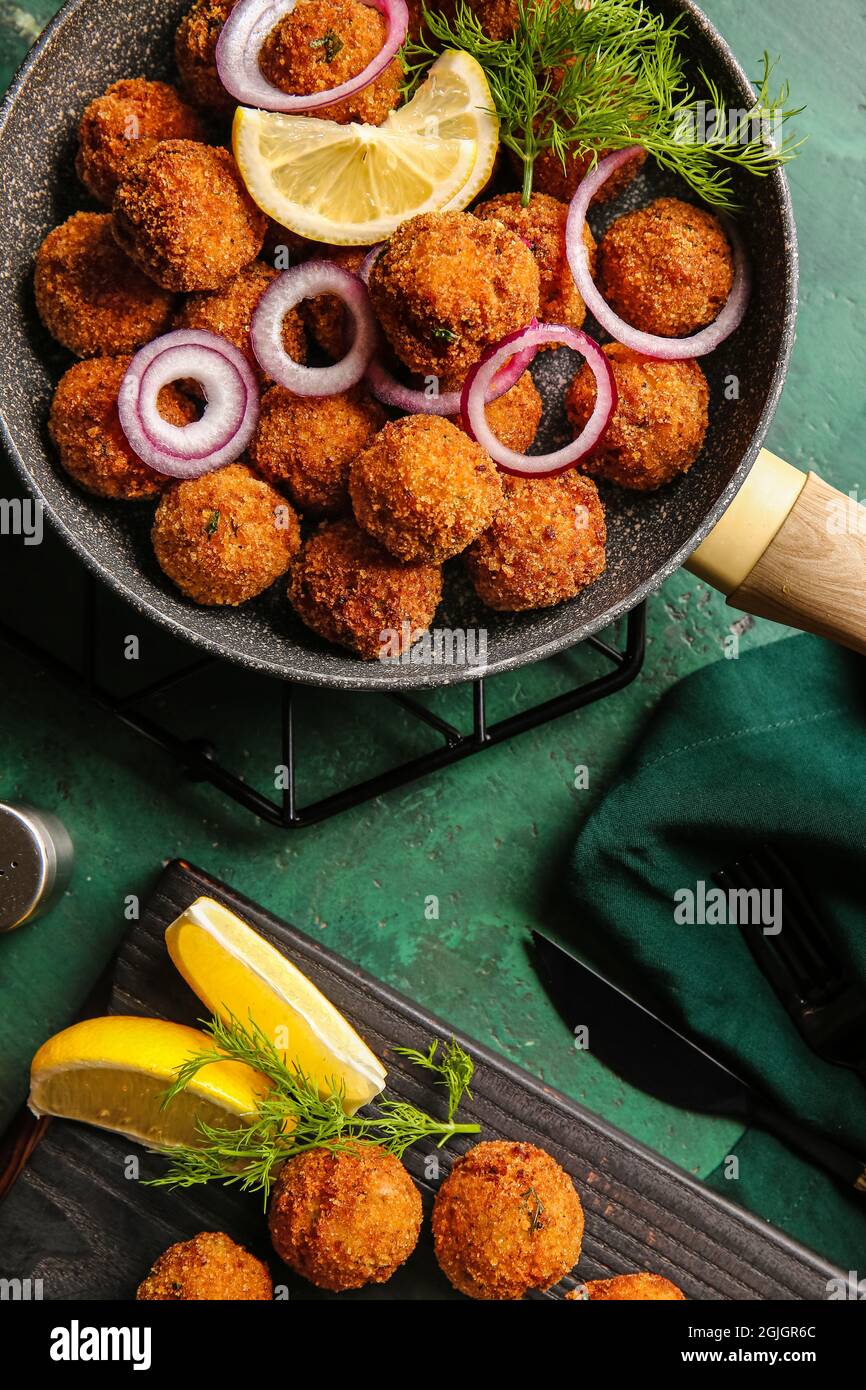 Frying pan with tasty cod cutlets on color background Stock Photo