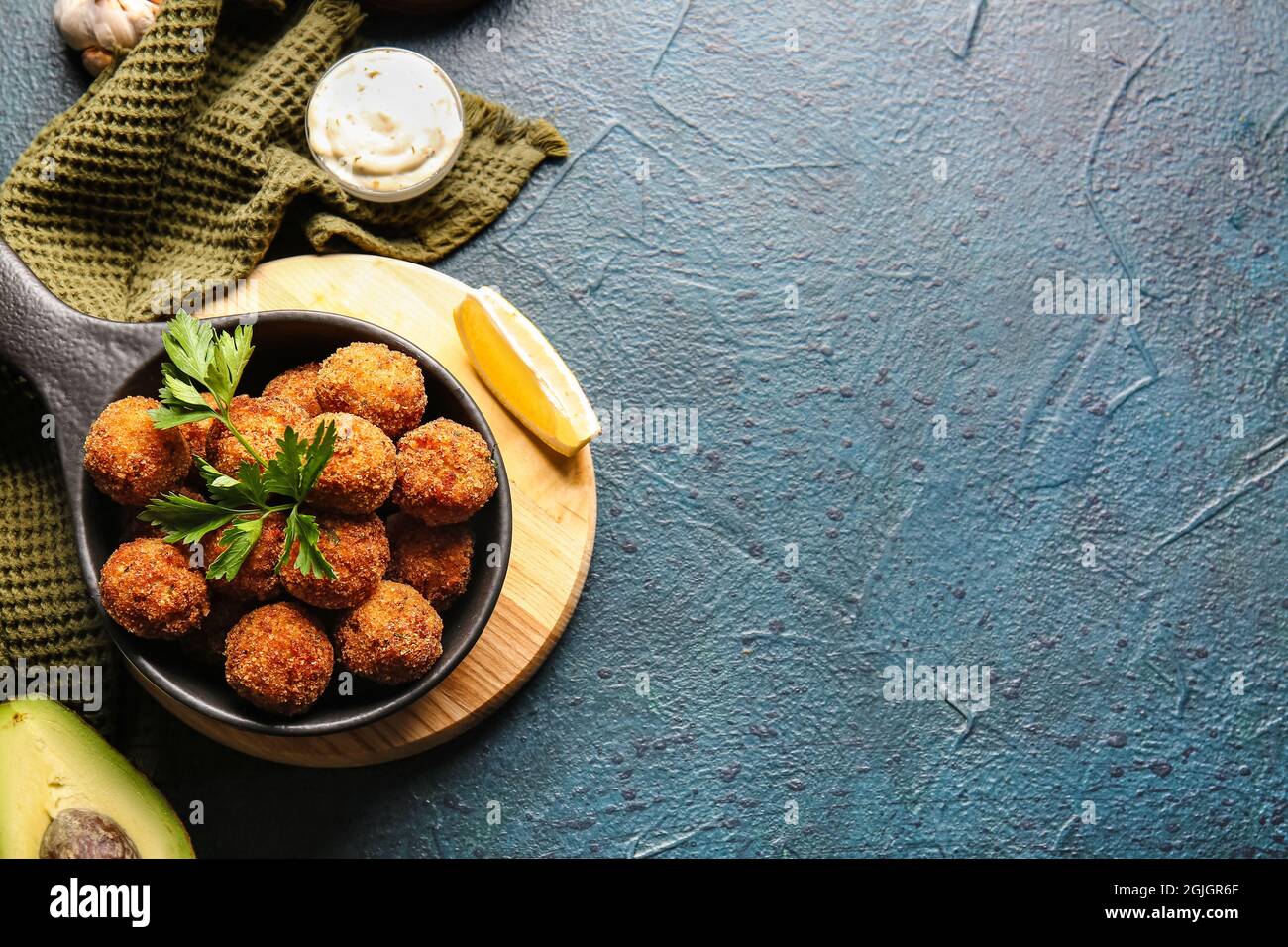 Frying pan with tasty cod cutlets and sauce on dark background Stock Photo