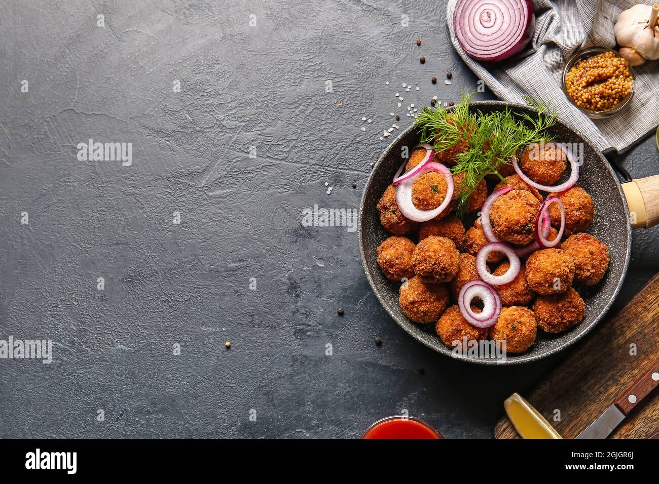 Frying pan with tasty cod cutlets on dark background Stock Photo