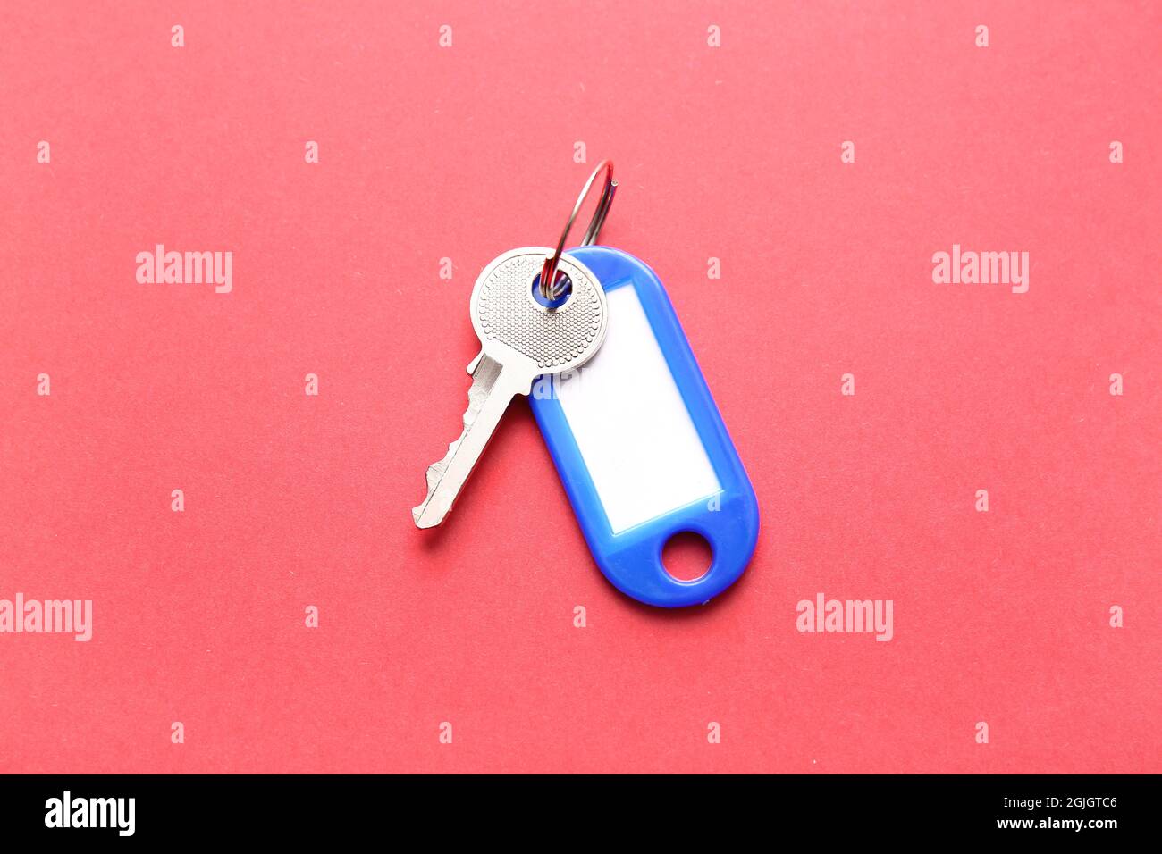 Plastic tag with key on color background Stock Photo
