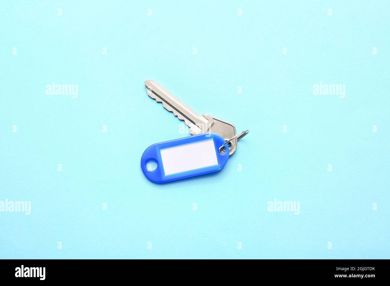 Plastic tag with key on color background Stock Photo