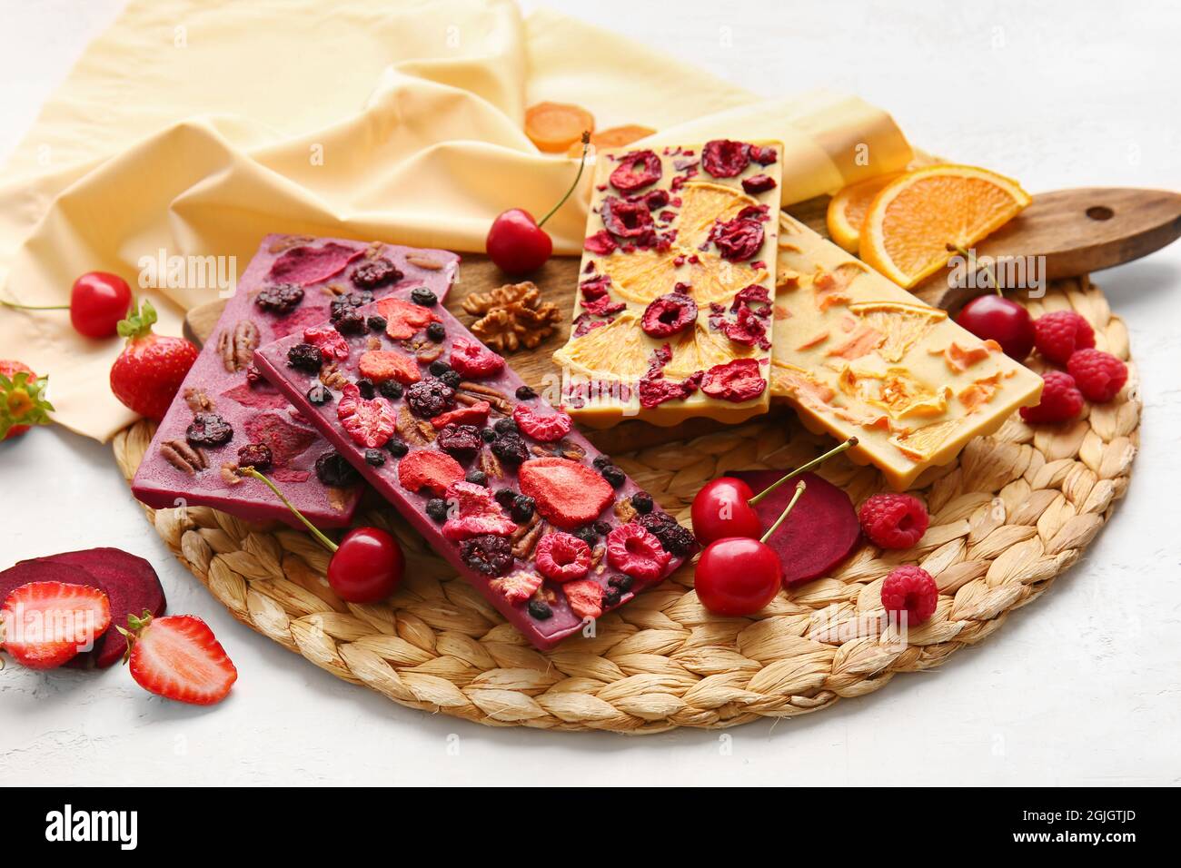 Handmade chocolate bars with fruits, berries and nuts on white ...