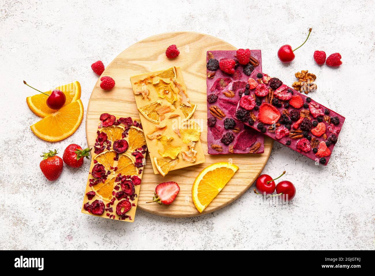 Handmade chocolate bars with fruits, berries and nuts on light ...