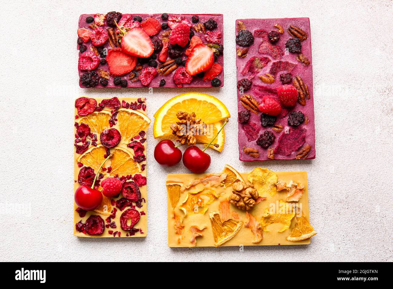 Handmade chocolate bars with fruits, berries and nuts on light ...