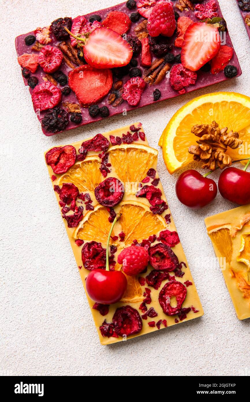 Handmade chocolate bars with fruits, berries and nuts on light ...