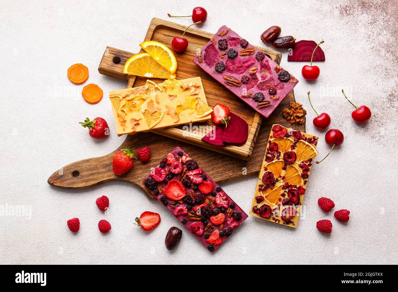 Handmade chocolate bars with fruits, berries and nuts on light ...