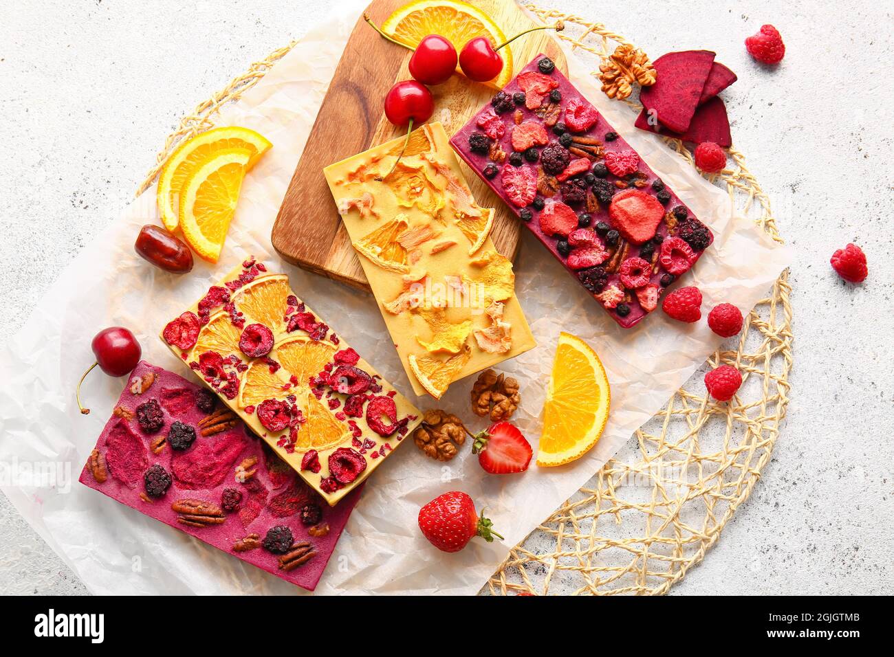 Handmade chocolate bars with fruits, berries and nuts on light ...
