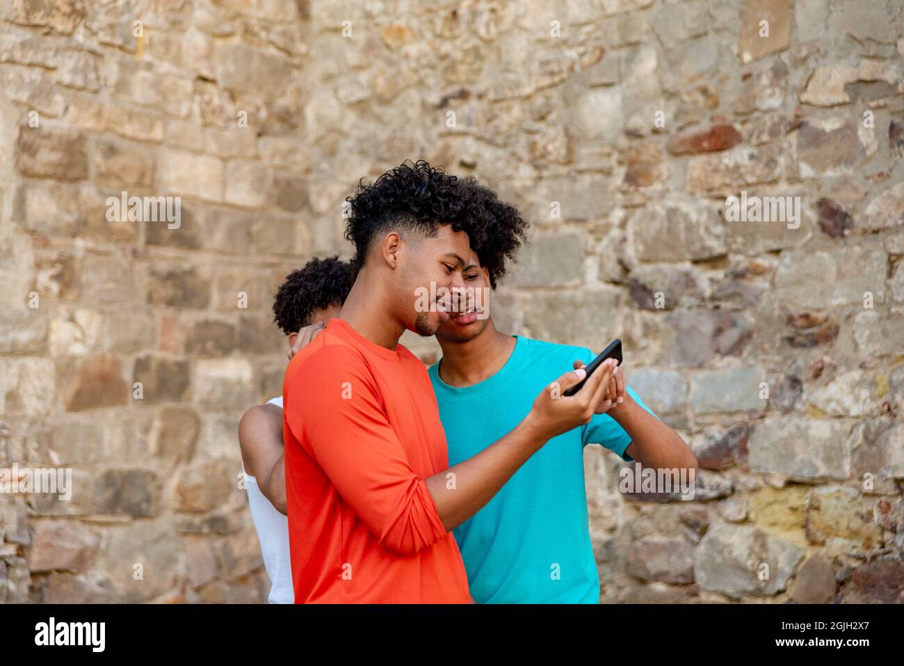 Multiethnic friends using mobile phone in the street Stock Photo