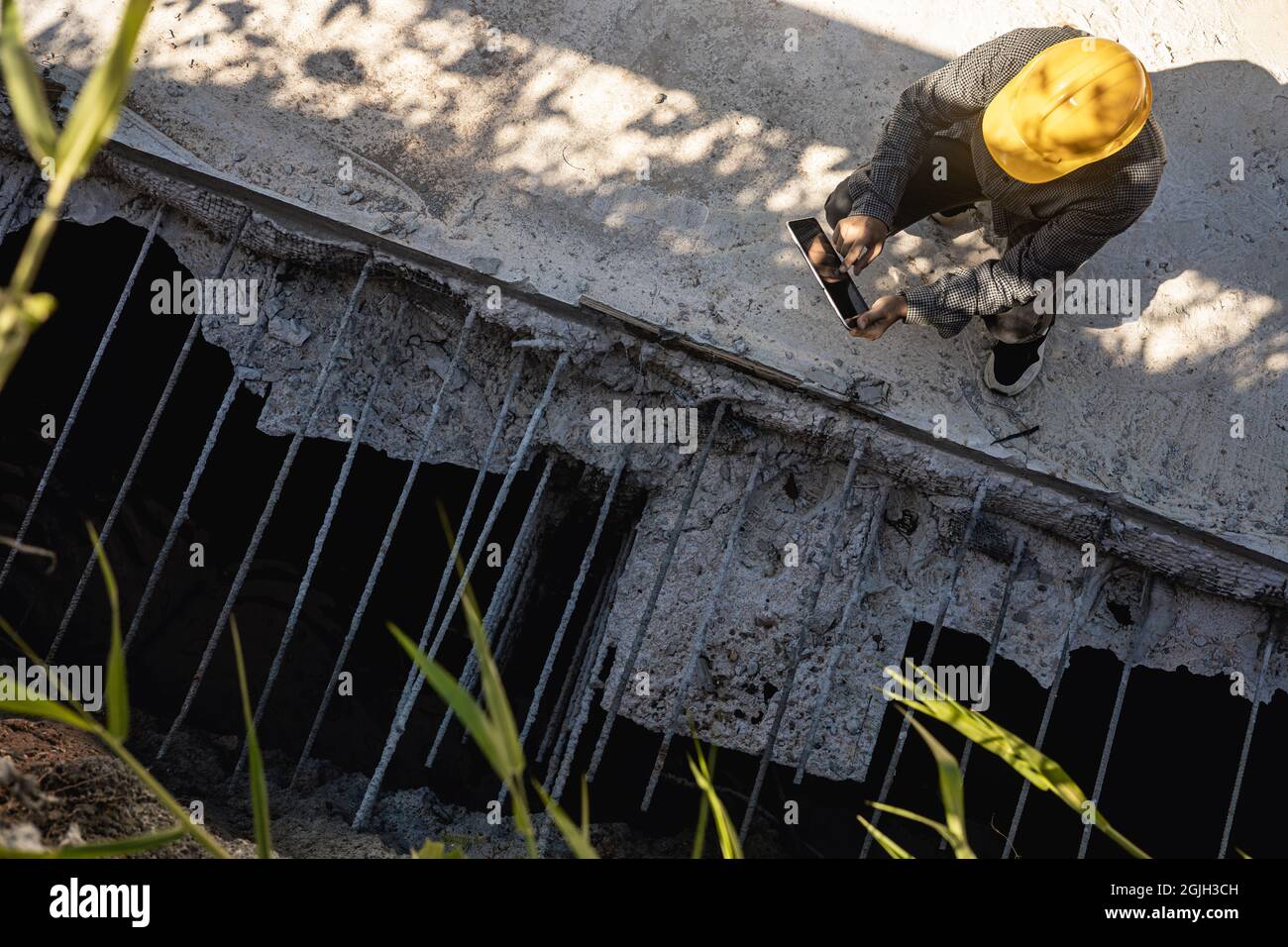 architect or civil engineer with hardhat on construction site checking schedule on tablet computer Stock Photo