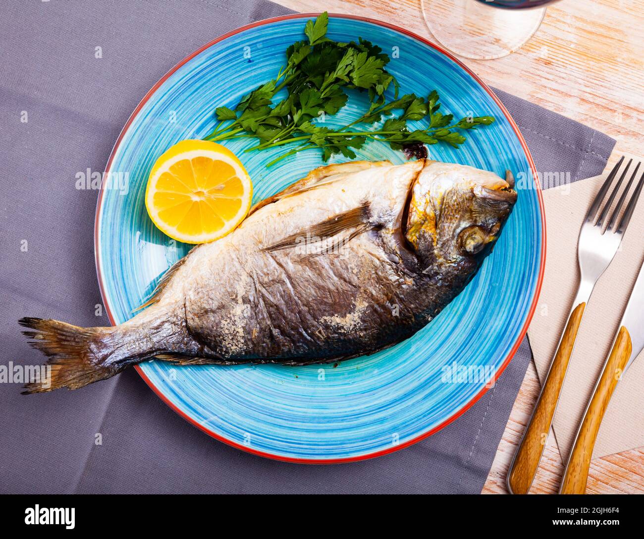 Baked in oven dorado fish with orange on plate Stock Photo