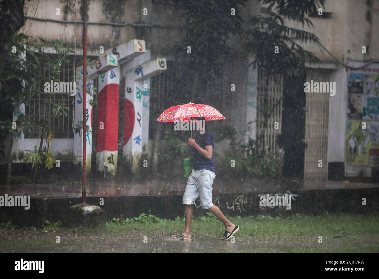 A man shelters from the rain with an umbrella. Monsoon downpour caused