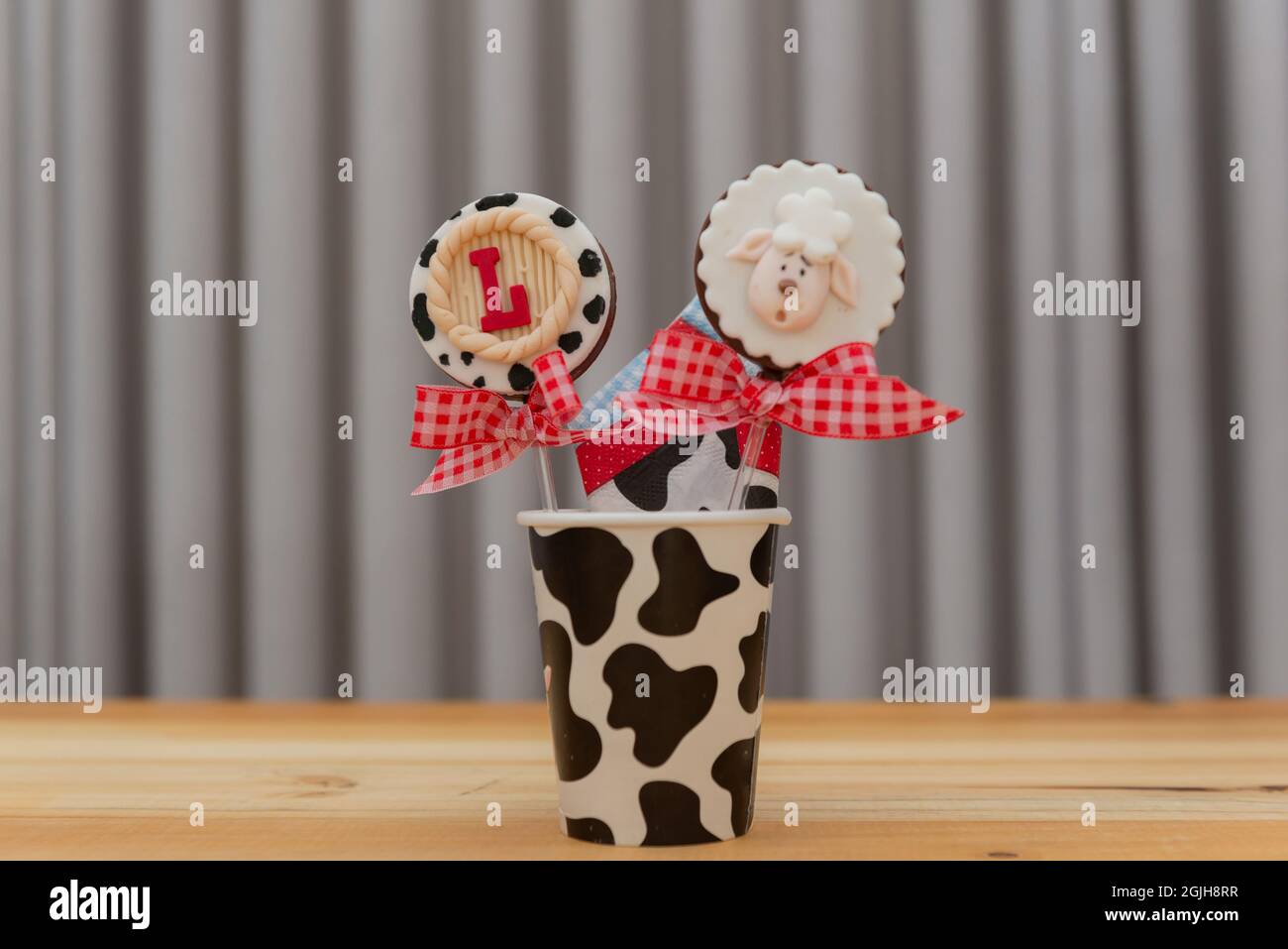Children's party decoration in country theme. 1 year anniversary. Lollipop with checkered bow. Stock Photo