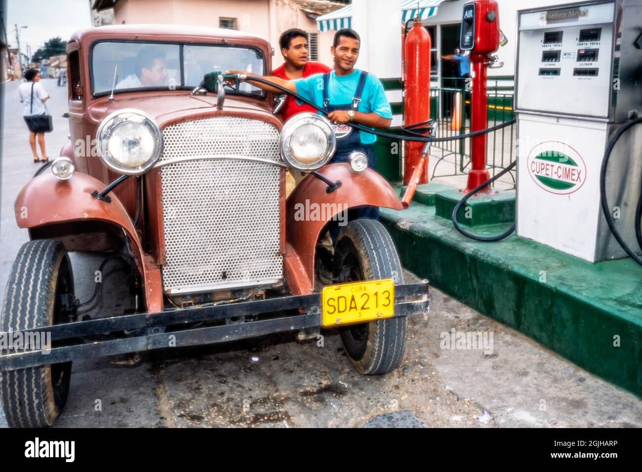 Cubans filling up an old classic American car with petrol, Sancti Spiritus, Cuba Stock Photo