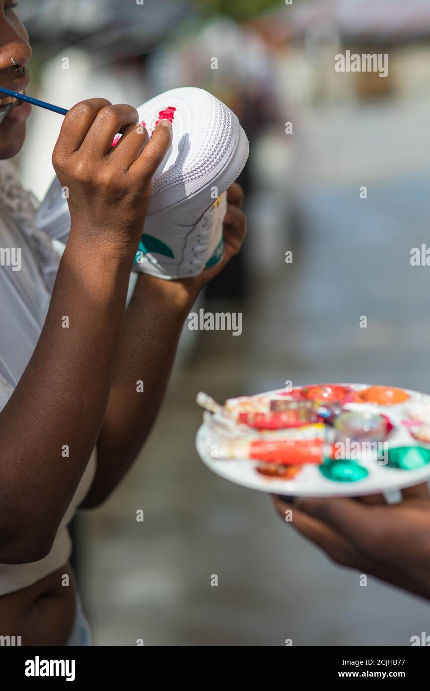 Girl from Comuno 13 painting the bottom of her sneakers. Stock Photo