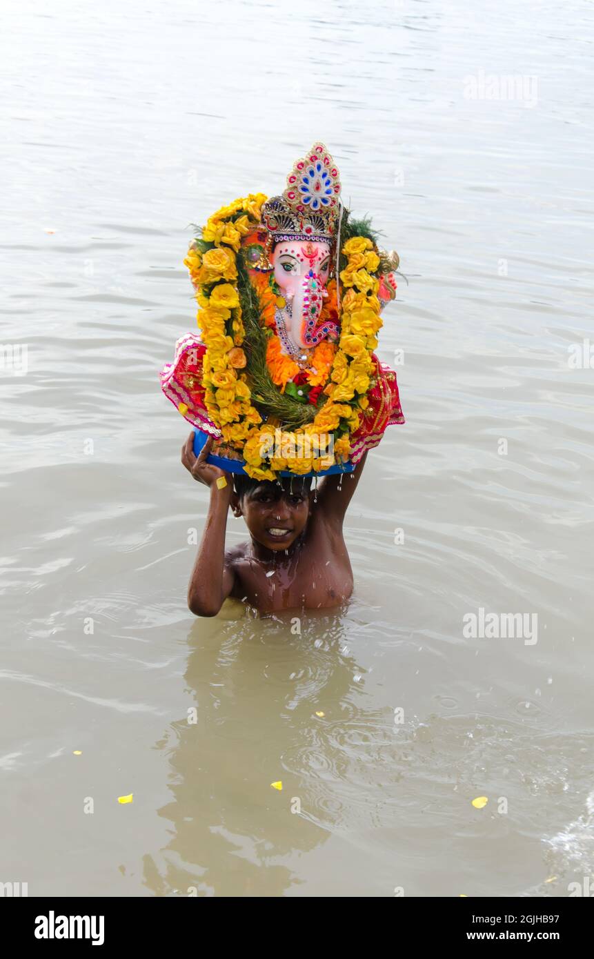 A boy holding Ganesha idol before immersion. Ganesh Chaturthi celebrations. Stock Photo