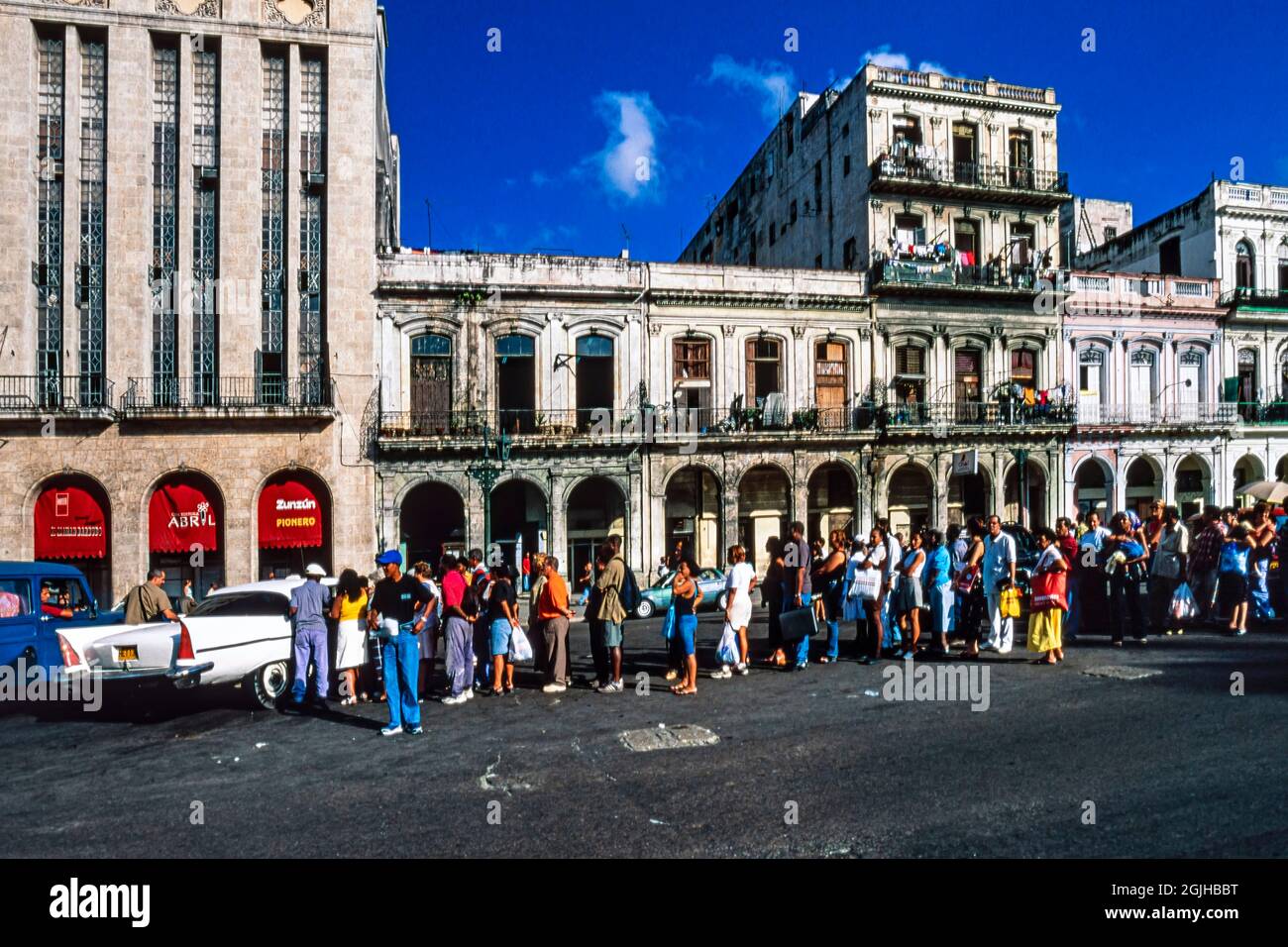 Cubans in long queue waiting for a shared taxi, central Havana, Cuba Stock Photo