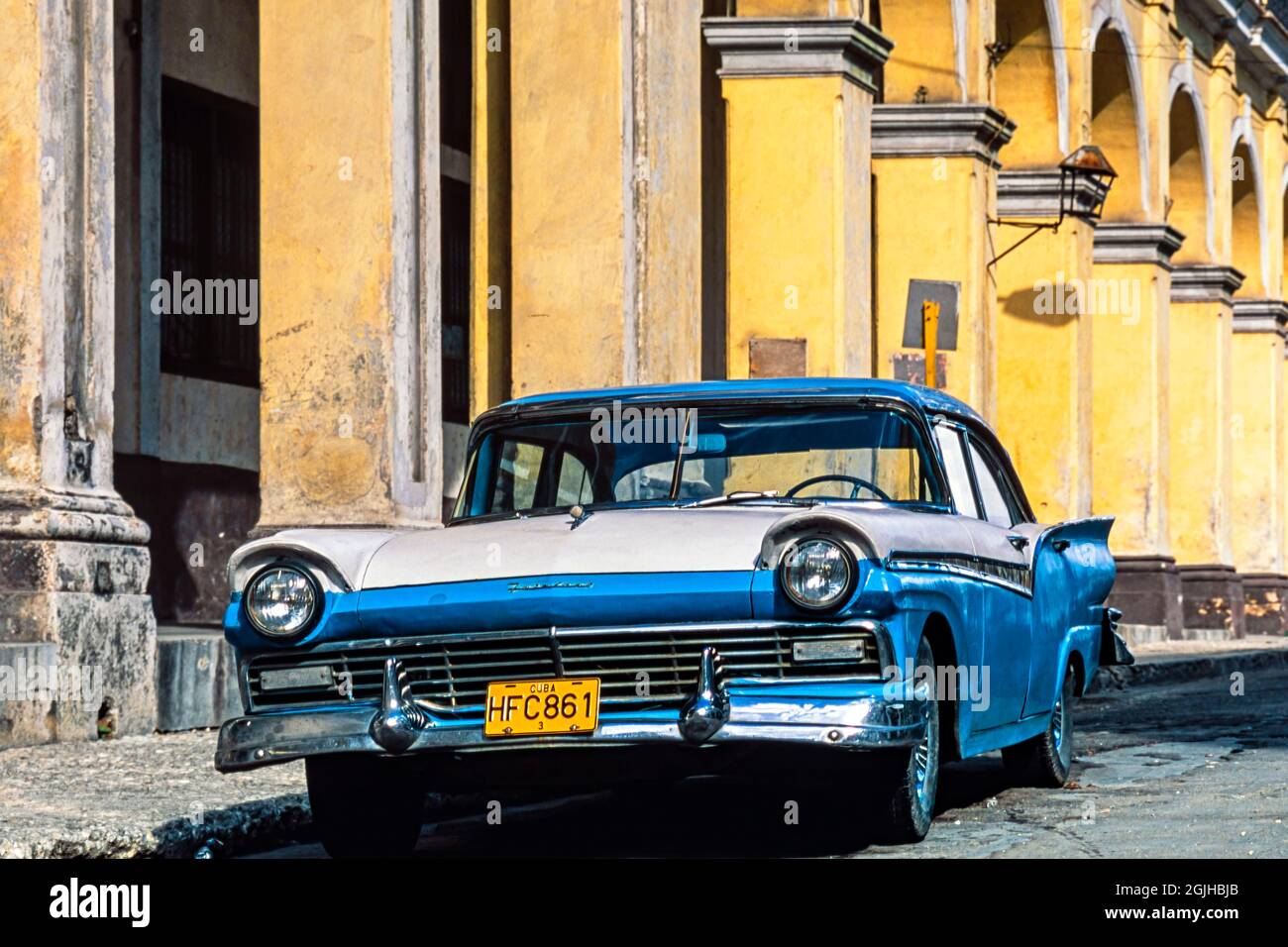Classic American 1957 Ford Fairlane parked outside colonial building, Havana, Cuba Stock Photo