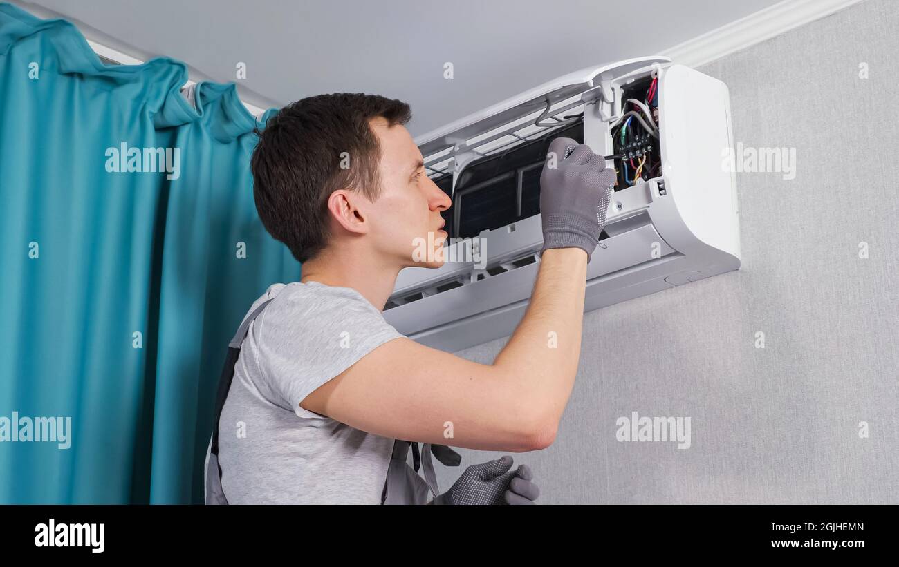 Concentrated electrician fixes electrical circuit panel Stock Photo