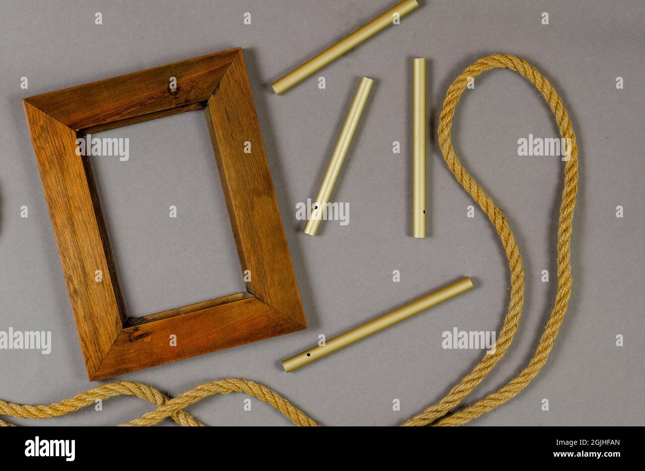 Empty photo frame and rope against a gray background. Wooden pic Stock Photo