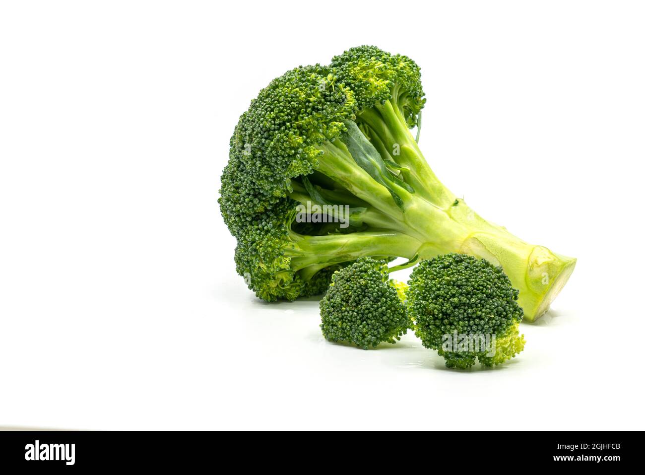 Close up fresh whole broccoli and cut broccoli on white background