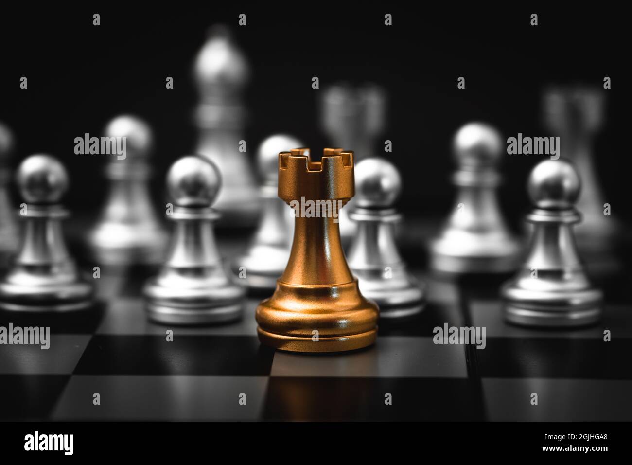 Gold Rook or Castle Tower Chess piece closeup on chess board game. Elite Company leader concept. Stock Photo