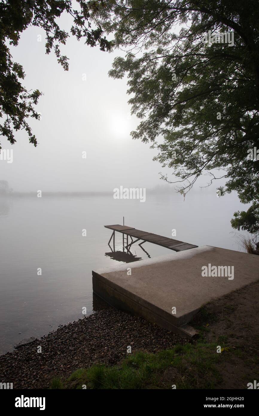 Jetty in the misty river Meuse in Geijsteren in the North of Limburg Stock Photo