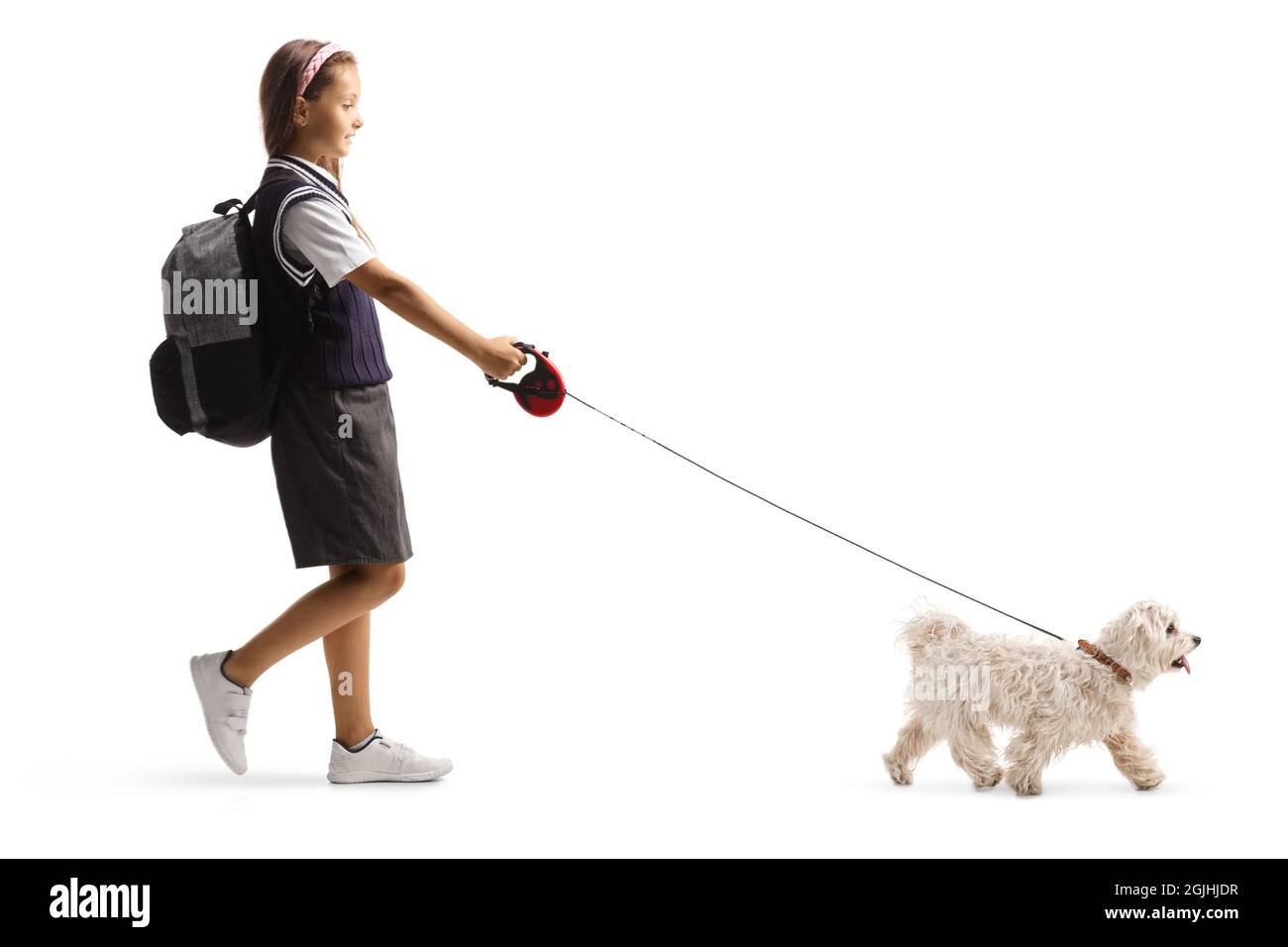 Full length profile shot of a schoolgirl with a backpack walking a