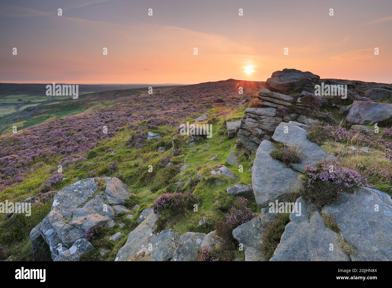The sun rises over an outcrop of gritstone on the summit of Beamsley Beacon, a hill in Wharfedale, Yorkshire Dales National Park, UK Stock Photo