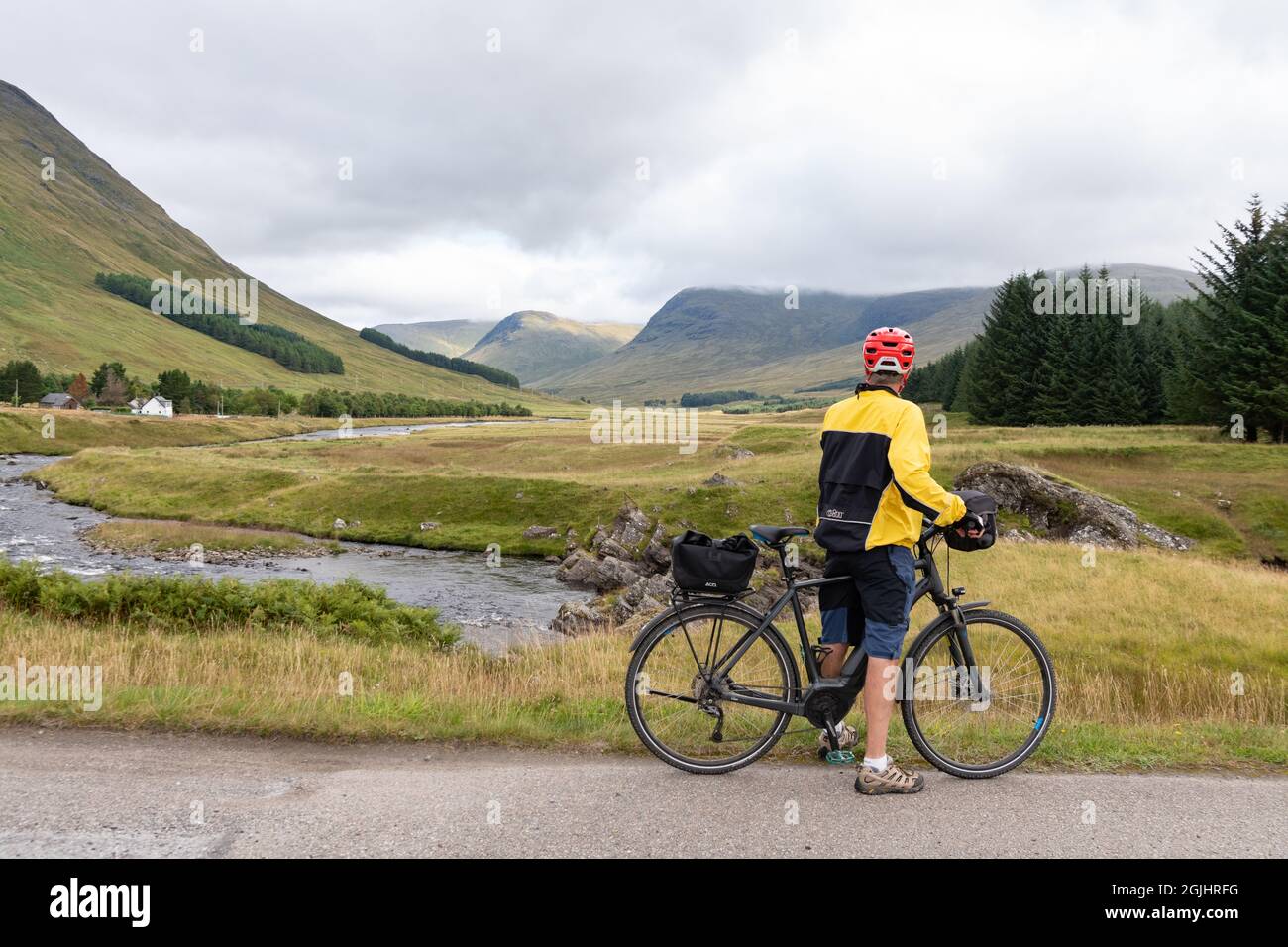 Cycling Glen Lyon, Perthshire, Scotland - cyclist looking at the view down Glen Lyon and River Lyon, Scotland, UK Stock Photo