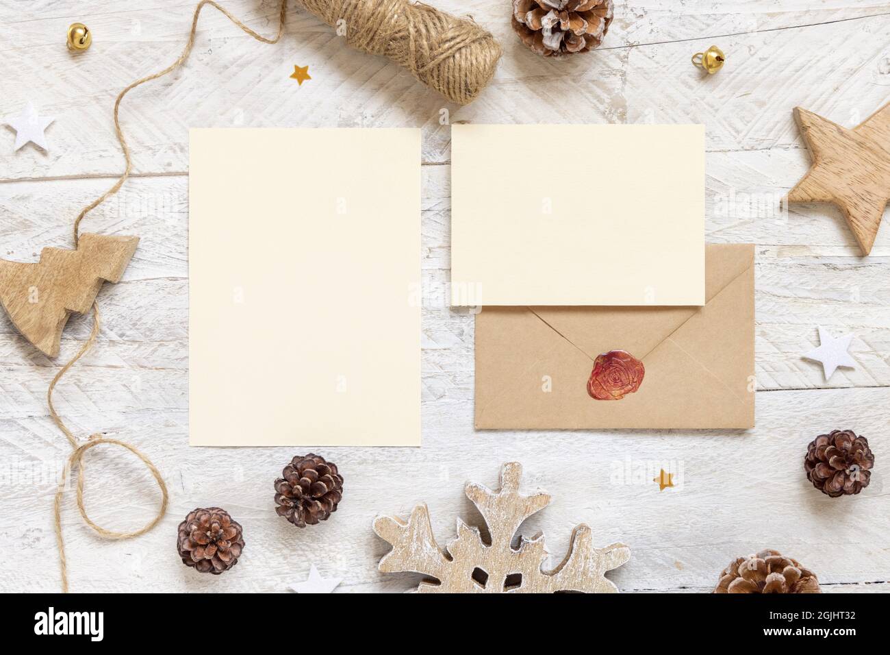 Winter Christmas Composition with a cards and sealed envelope flat lay. Christmas and New Year greeting cards template with pine cones, wooden decorat Stock Photo